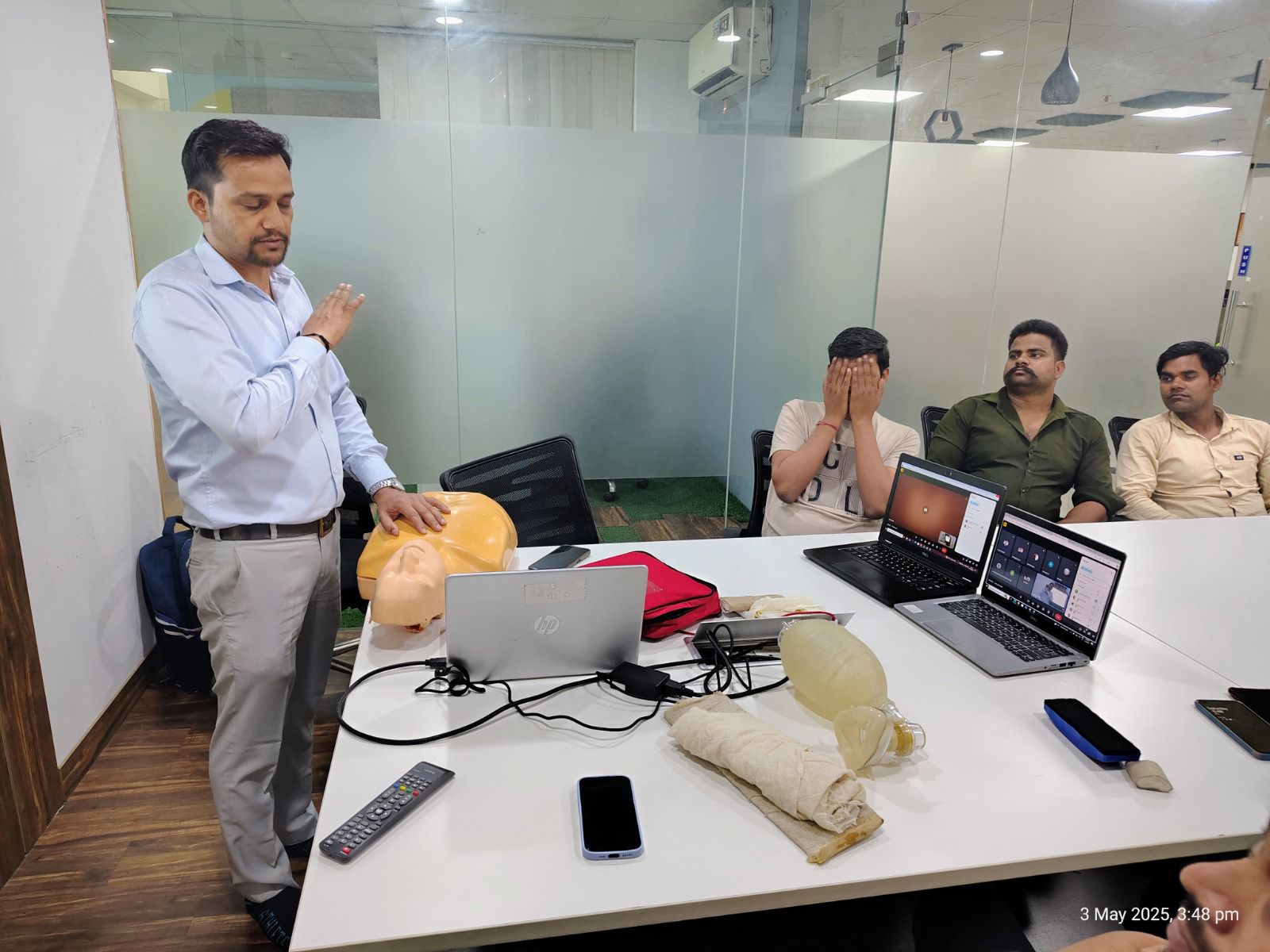 Trainer demonstrating chest compressions on a CPR mannequin